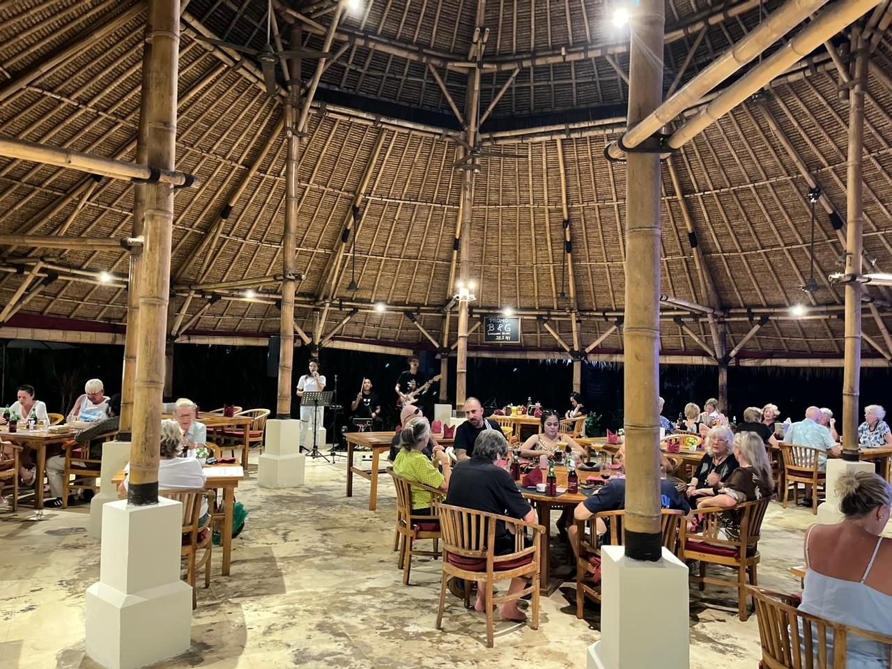 Guests dining under the thatched roof with live music at The Dining Room Candidasa